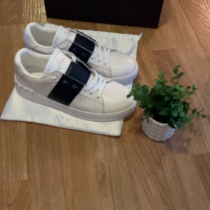 Valentino Garavani opens vita sneakers - Snygga vita sneakers från Valentino Garavani med bred svart rem över vristen och vita skosnören. Priset kan diskuteras!🤩🤩💫