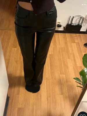 Svarta skinn byxor - Säljer ett par svarta skinnbyxor med rak. Byxorna har normal midja. Lite slitna bak (som kan ses på sista bilden) men inga hål.