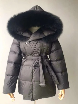 Svart dunjacka med pälskantad huva - Snygg och varm vinterjacka i mycket fint skick. Har stor fluffig pälsluva och skärp i midjan som ger jättefin passform. Den lilla metallbiten längst ut på skärpet saknas, men skärpet fungerar precis som vanligt och syns knappt när jackan är på. Använd ett fåtal gånger. Köptes från ett företag på instagram (nypris 2800kr)  Storlek S.