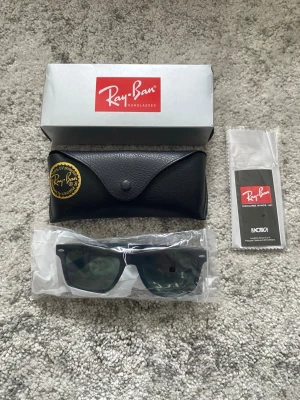 Ray-Ban solglasögon  - Ett par svarta Ray-Ban solglasögon i nytt skick, oanvända. Orginalförpackning, etui med mera medföljer självklart (se bild 1). Hör gärna av er om det är nåt ni undrar!