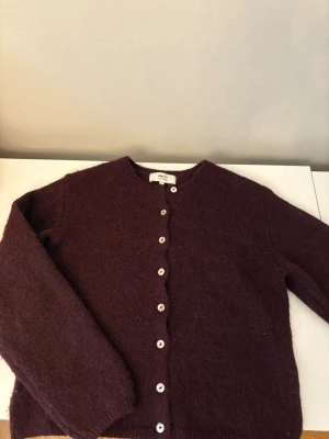 Vinröd kofta från Gina  - Mysig vinröd kofta från Gina tricot med vita knappar framtill.