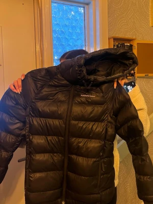 Svart pufferjacka från Peak Performance - Säljer en svart pufferjacka från Peak Performance i storlek XS med stor huva och dragkedja framtill. Perfekt för kalla vinterdagar och riktigt skön att bära, riktigt snygg oxå. Jag själv skulle säga att den ändå är i väldigt bra skick, säljer då jag vill köpa nytt.