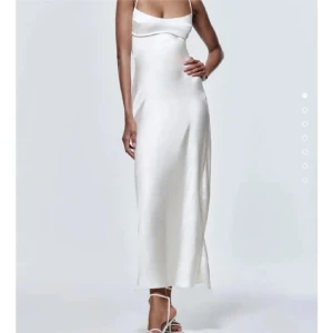 Vit satinklänning  - Superfin satinklänning från Zara. Har spänne i ryggen och slits där bak. Använd men fortfarande bra skick. Passar perfekt till bal eller andra festligheter 