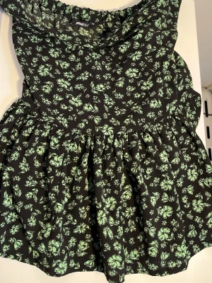 Svart kjol med grönt blommönster - Supersöt svart kjol från Gina Tricot med grönt blommönster. Kjolen är en lätt utsvängd kjol. Perfekt för dig som gillar blommiga prints och vill ha en feminin look.
