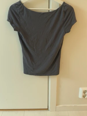 Soft touch top från Ginatricot  - Grå kortärmad topp från ginatricots soft touch kollektion. Storlek M. Använd fåtal gånger, säljs då jag inte gillar passformen. Skulle säga att den är normal till storleken men detta kan såklart skiljas åt från individ till individ. Använd men i väldigt fint skick fortfarande, kan inte se några hål eller liknande. Obs!!! Skriv innan köp då den ligger ute på fler sidor 