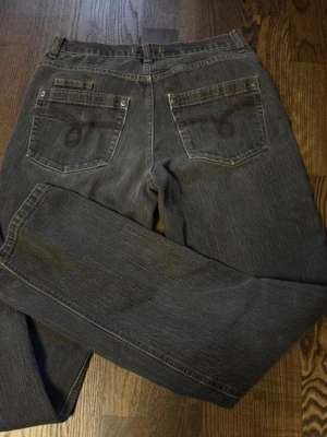 Grå raka jeans med broderade fickor - Snygga grå jeans med raka ben och coola broderade detaljer på bakfickorna. Klassisk femficksmodell med knapp och dragkedja framtill. Jeansen har en diskret tvättad look och är tillverkade i denim med lätt stretch för extra komfort.