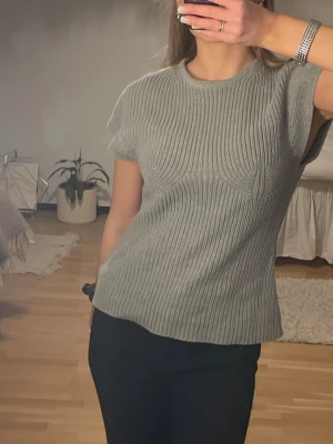 Grå ribbstickad topp med kort ärm - Snygg grå ribbstickad topp med korta ärmar och rund halsringning. Kommer tyvärr inte till användning, aldrig använd 💫 storlek XS från NAKD