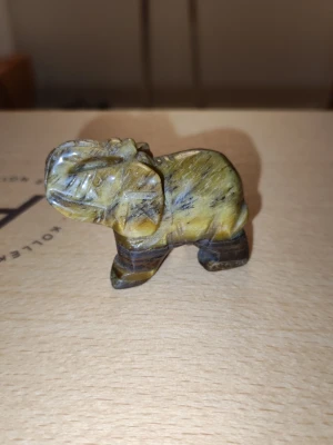 Elefantfigur i ädelstenen tigeröga - Säljer en handgjord elefantfigur snidad i tigeröga sten. Storlek: 3,5x2,2x4,9cm.   Från Chile, Maitencillo   Finns fler ädelstenar i min profil ❣️