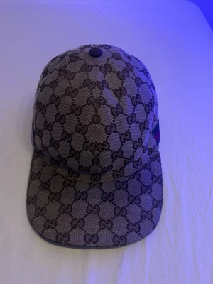Gucci keps med GG-mönster - Säljer min guccci keps för den inte kommer till användning,den är i bra skick ända nackdelen är att den gått sönder lite vid kanterna men man märker de knappt.DEN ÄR ÄKTA!