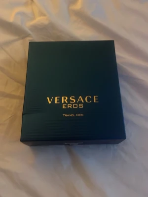 Versace Eros Travel Deo parfymset - Snyggt parfymset från Versace Eros med både Eau de Toilette och deodorant stick. Flaskorna är blå med gulddetaljer och har den ikoniska Medusa-loggan. Perfekt för dig som vill ha en fräsch och maskulin doft i lyxig förpackning.