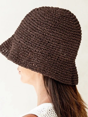 Brun virkad bucket hat - Säljer en brun virkad bucket hat i ett luftigt och mjukt material (strå). Hatten har en klassisk form med nedåtlutande brätte och är perfekt för soliga dagar. Passar dig som gillar en avslappnad och trendig stil. One size.