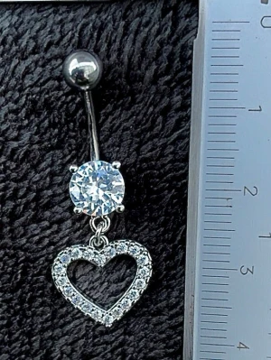 NY oanvänd Navelpiercing med hänge | Kirurgiskt stål | Hjärta och vita stenar  - 💕30% Bundle-rabatt vid köp av minst 2 artiklar. ⭐️NY oanvänd piercing i kirurgiskt stål; rostfritt och säkert för läkta piercingar.                               📏MÅTT ⭕️Stavens längd: 10mm ⭕️Stavens tjocklek: 1,6mm ⭕️Smyckets totala längd: 35mm                                                                         🤍Färger: Silver och vit                                                            💌Skickas spårbart via Plick SafePay.