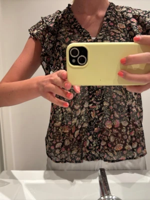 Blommig blus med volanger - Söt blus som är lite tunnare med blommor på. Perfekt till sommaren! Från mango och nästan aldrig använd. 