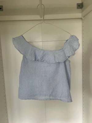 Sommartopp  - Säljer denna söta blå-vit randiga toppen, off shoulder, perfekt till sommaren 