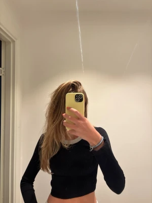 Svart croppad ribbad långärmad topp - Säljer en svart croppad långärmad ribbad topp med vit kant från Zara. 
