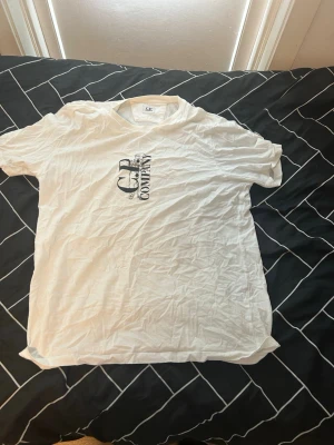 C.P. Company T-shirt Vit – Strl L – Äkta & Helt Ny - Säljer en äkta C.P. Company T-shirt i storlek L. T-shirten är helt ny och oanvänd, i perfekt skick. Stilren vit design med C.P. Company-logga på bröstet som ger en modern och exklusiv look. Perfekt för både vardag och streetwear.  ✔️ Märke: C.P. Company ✔️ Storlek: L ✔️ Skick: Helt ny och oanvänd ✔️ 100 % äkta ✔️ Färg: Vit ✔️ Mjuk och bekväm passform ✔️ Stilren och tidlös design ✔️ Perfekt för vardag och streetwear  💰 Pris: Kan diskuteras vid snabb affär.  📩 Skicka meddelande eller be om mer bilder 