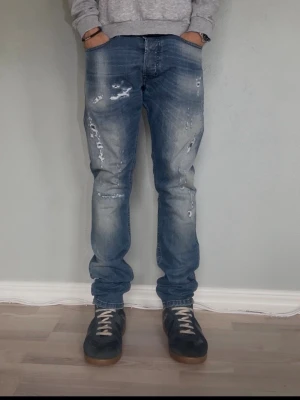 Diesel Tepphar W29 L32 – D.N.A. F/W 2016 | Slim-Carrot Stretch - DIESEL TEPPHAR — D.N.A. RELEASE  Storlek: W29 L32 Passform: Slim-carrot Material: Stretch denim Modell: Tepphar Kollektion: Diesel D.N.A. F/W 2016 — limiterad release  Tepphar är en av Diesels mest ikoniska modeller — slim vid låret med en lätt avsmalnande carrot-silhuett som sitter perfekt utan att vara tajt. D.N.A.-kollektionen från 2016 är en limiterad linje vilket gör dem svårare att hitta ny.  Modellen på bilden är 175cm och väger 65kg.  Skick: Mycket bra Nypris: ca 1 800 SEK