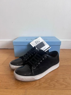 Lanvin Cap Toe - Säljer ett fett par mörkblåa lanvins som är storlek 42-43. Fick skorna i julklapp, har använd de några gånger sedan dess. Box och tillbehör medföljer. Skickar även med ett par nya skosknören då de originala är ganska slitna. Skriv vid mista lilla fråga eller fundering!
