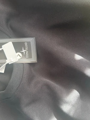 Svart sweetshirt från Stone Island - Snygg svart hoodie från Stone Island med klassisk logotyp-patch på ärmen. Helt ny