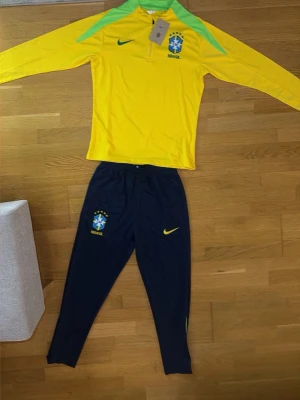Brasilien Nike träningsset  - Snyggt träningsset från Nike med Brasiliens landslagslogga. Skön material och stilig. På kläderna står de storlek S men kläderna är liten i storlek så då blir de XS istället 