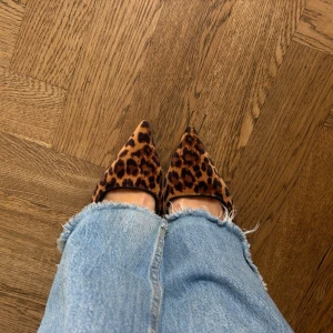 Leopardmönstrade spetsiga klackar - Säljer ett par klackar med leopardmönster och spetsig tå. Skorna har öppen häl med smal rem och är i ett mjukt tygmaterial. Supersnygga och perfekta att spicea upp en ganska stilren outfit med🌟🌟