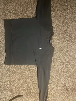 Svart sweatshirt från Polo Ralph Lauren - Klassisk svart sweatshirt från Polo Ralph Lauren med rund halsringning och den ikoniska vita logon broderad på bröstet. Tröjan har långa ärmar och ribbade muddar vid ärmslut och nederkant. Perfekt för en clean och stilren look.