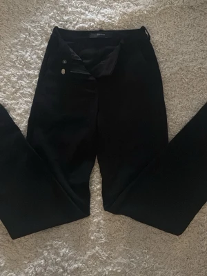 Svarta kostymbyxor från Vero Moda - Snygga svarta kostymbyxor från Vero Moda i rak modell. Byxorna har knapp- och dragkedjestängning samt diskreta fickor. Perfekta för en clean och stilren look. Super nice matrial!