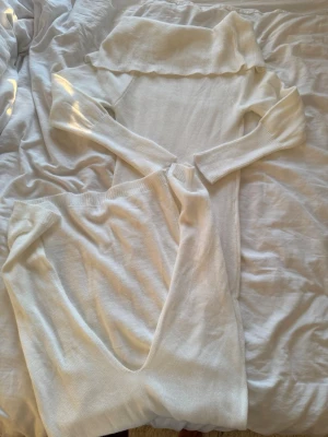Vit stickad body med bred krage - Säljer en vit stickad body med lång ärm och bred, nedvikt krage. Materialet är mjukt och stretchigt, perfekt för att skapa en clean och stilren look. Passar dig som gillar enkla men snygga detaljer.