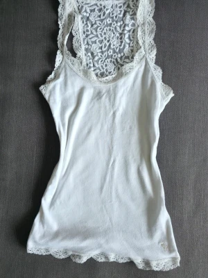 Vintage Abercrombie and Fitch linne  - Vintage Abercrombie and Fitch vitt linne med spets i figursydd modell. Fanns i butik under mitten av 2000-talet. Den har mindre tecken på användning men är i fint skick.