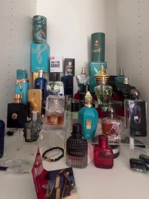 Mix av exklusiva herrparfymer byten. - Samling av herrparfymer i olika färger och former, flera flaskor i glas med detaljer i guld, blått, svart och turkost. Märken som Valentino och Only The Brave syns. Flakongerna har unika designer, vissa med metallock och dekorativa inslag. Perfekt för dig som gillar variation och stil.