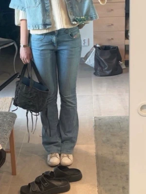 Ljusblå bootcut jeans - Säljer ett par ljusblå bootcut jeans med klassisk femficksmodell och utsvängda ben. Jeansen har normal midja och är tillverkade i mjukt denimtyg. Perfekta för dig som gillar retrovibbar och en avslappnad stil.
