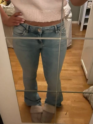 Ljusblå bootcut jeans med hög midja - Säljer ett par ljusblå jeans med bootcut-modell och låg midja.