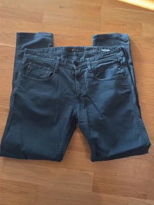 Mörkblå jeans från Replay - Säljer ett par mörkblå jeans från Replay, modell Anbass. Klassisk femficksdesign med raka ben och normal midja. Jeansen har snygga söm-detaljer och är tillverkade i ett mjukt, stretchigt material för extra komfort.