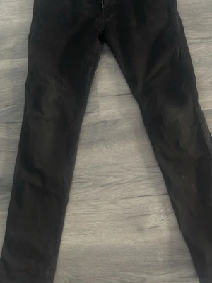 Svarta slim fit jeans - Snygga svarta jeans med slim fit passform och klassisk femficksdesign. Jeansen har dragkedjegylf och raka ben. Perfekta för en stilren och enkel look. 32 midjan, 32 längd 