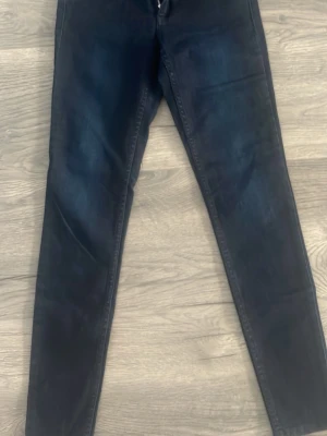 Mörkblå slim jeans - Säljer ett par mörkblå jeans med slim passform. Klassisk femficksmodell och dragkedja i gylfen. Perfekta till vardags för en clean och enkel stil. 27 midjan, 30 längd 