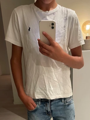 Vit t-shirt från Polo Ralph Lauren - Klassisk vit t-shirt från Polo Ralph Lauren med den ikoniska lilla loggan broderad på bröstet. T-shirten har rund halsringning och korta ärmar. Perfekt skick!