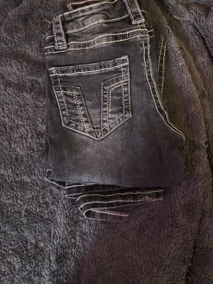 Svarta jeans med kontrastsömmar från gina tricot storlek 158 barn - Säljer ett par svarta jeans med vita kontrastsömmar och snygga bakfickor med dekorativa detaljer. Jeansen har klassisk femficksmodell och raka ben. Perfekta för dig som gillar en cool och avslappnad stil.