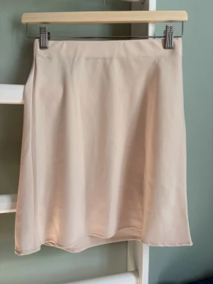 Kort glansig kjol - Glansig A-linje kjol från bikbok. Stl: XS med respår i midjan. Mycket bra skick då den aldrig är använd.