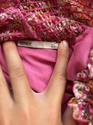 Blommig volangkjol från ONLY - Supersöt blommig kjol från ONLY i storlek 164. Kjolen har flera volanger och ett smockat midjeband för skön passform. Färgen går i rosa toner med små vita och gröna blommor. Perfekt för dig som gillar en romantisk och lekfull stil.