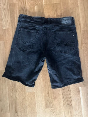 Svarta jeansshorts från Replay - Snygga svarta jeansshorts från Replay med klassisk femficksdesign och knappgylf. Shortsen har en rak passform och är tillverkade i ett slitstarkt bomullsmaterial. Perfekta för en avslappnad och cool stil.