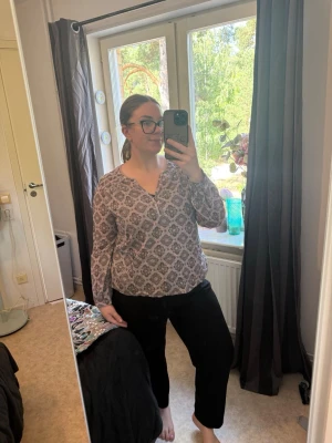 Mönstrad blus med V-ringning - Säljer en luftig blus med lång ärm och V-ringning. Blusen har ett bohemiskt mönster i beige och brunt, samt smockdetaljer vid axlarna. Perfekt till jeans eller svarta byxor för en avslappnad men snygg look. Från märket Odd Molly i storlek 4 som enligt deras storlekguide motsvarar en storlek L/XL. Mycket fint skick, jag hittar inga synliga anmärkningar eller defekter.
