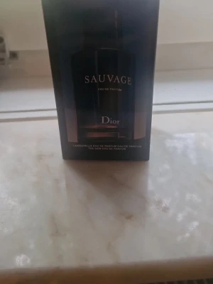 Dior Sauvage Eau de Parfum - Dior Sauvage Eau de Parfum i elegant svart förpackning. Flaskan har en stilren och modern design med silverdetaljer. En ikonisk herrdoft som kombinerar fräscha och kryddiga noter. Perfekt för dig som vill ha en exklusiv och tidlös parfym.