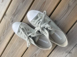 Vita Converse All Star låga sneakers - Säljer ett par klassiska vita/gråa Converse All Star sneakers i lågt snitt. Skorna har vita snören, gummitå och sula samt metallfärgade öljetter. 