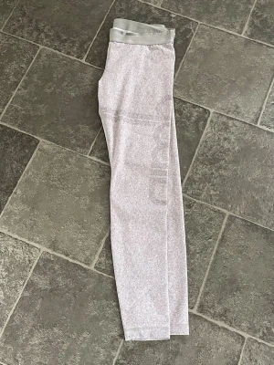 Ljusgrå träningstights Aim’n  - Snygga ljusgrå Aim’n träningstights med bred resår i midjan. Tightsen har en diskret melerad design och är tillverkade i ett stretchigt material som passar perfekt för gymmet eller löprundan.
