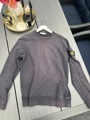 Grå sweatshirt från Stone Island - Säljer denna mörkblå tröjan från Stone Island. Använd en del, därav några små slitage och solblekt. Däremot syns det inte lika mycket i verkligheten. Skriv privat för fler bilder eller frågor!!