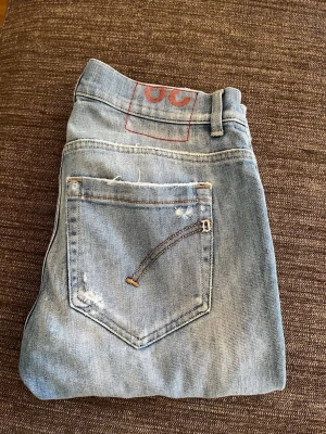 dondup jeans - Säljer ett par äkta✅ ljusblå dondup jeans med raka ben och slitningar på både fram- och baksida. Jeansen har klassisk femficksmodell, knappgylf och detaljerade sömmar på bakfickan.Riktigt fet plagg som funkar året om. Nypris ca 2600. Skriv i dm om ni har några frågor☺️