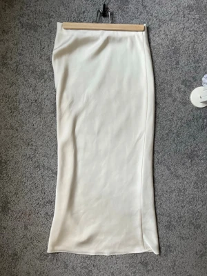 Vit långkjol i satin från Zara - Vit/cream färgad långkjol från Zara i mjukt satin.  Använt fåtal gånger💗💗
