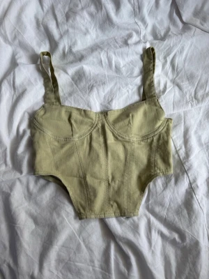 Ljusgrön body med breda axelband - Trendig ljusgrön body med breda axelband och markerade sömmar. Bodyn har bygelinspirerad kupa och är tillverkad i ett mjukt, stretchigt tyg som formar sig efter kroppen. Perfekt för att skapa en cool och modern look.