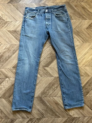 Levi's 540 - Säljer ett par ljusblå jeans med rak passform och klassisk femficksdesign. Jeansen har normal midja och subtila slitningar framtill. Materialet är denim i bomull och de har en tidlös look som passar till det mesta. Längd 108cm Bredd 42cm