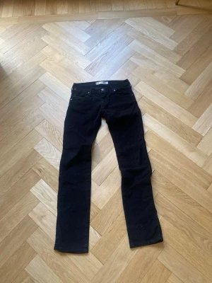 Manchester byxor  - Säljer ett par svarta jeans med rak passform och klassisk femficksdesign. Jeansen har normal midja och stängs med knapp och dragkedja. Materialet är Manchester. 
